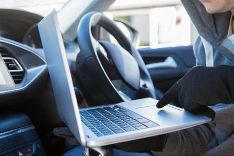 Thief Using Laptop To Hack Into Car Security Software Stock Photos