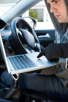Thief Using Laptop To Hack Into Car Security Software Stock Photos