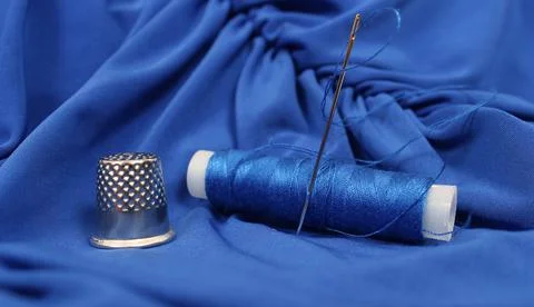 Thimble and Thread on Blue Fabric Stock Photos