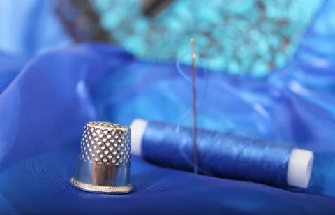 Thimble and Thread on Blue Fabric Stock Photos