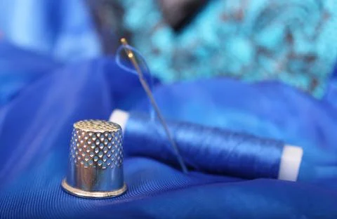 Thimble and Thread on Blue Fabric Stock Photos