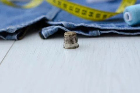Thimble close-up against the background of things, centimeter and thread Stock Photos