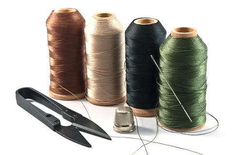 Thimble,needles,spools and scissors for sewing on a background thread 스톡 사진