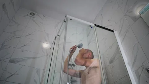 Thin bald man washes himself in the shower stall. Stock Footage 280482247