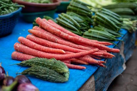 Thin carrots lying on tablecloth next to other vegetables at Goa bazaar in India Stock Photos