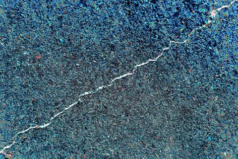 A thin crack in a concrete slab, changed colors, phot in blue tones Stock Photos