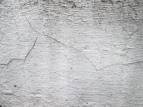 A thin crack in the rough white wall. The beginning of the fracture of the 스톡 일러스트
