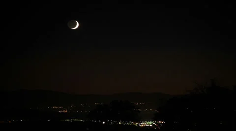 Thin crescenet moon with earth glow setting over city in time lapse Stock Footage 35845367