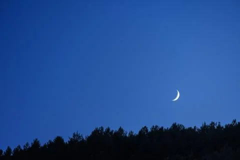 Thin crescent moon in the blue sky of the twilight Fotos Stock