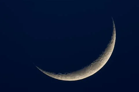A thin crescent moon on a dark blue background Fotos Stock