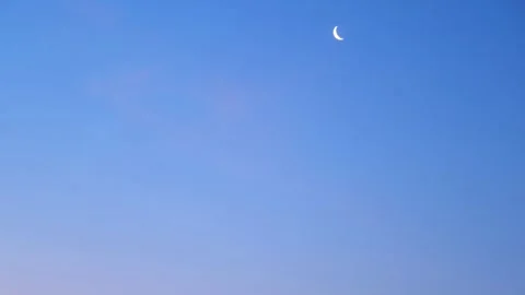 Thin crescent moon rising in the clear twilight sky. Celestial body tracking Vídeos de archivo 340356574