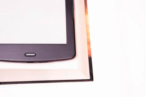 Thin e-book is over a rough paper book. Stock Photos