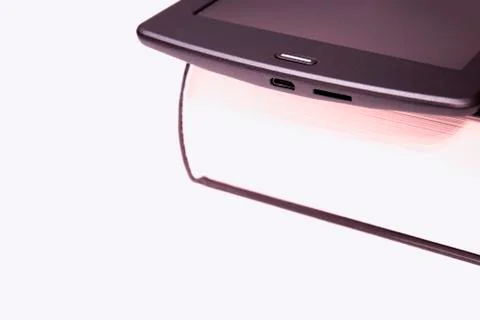 Thin e-book is on a rough paper book..New paper technologies. Stock Photos