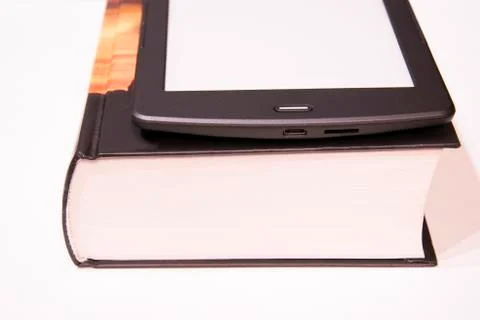 Thin e-book is on a rough paper book..New paper technologies. Stock Photos