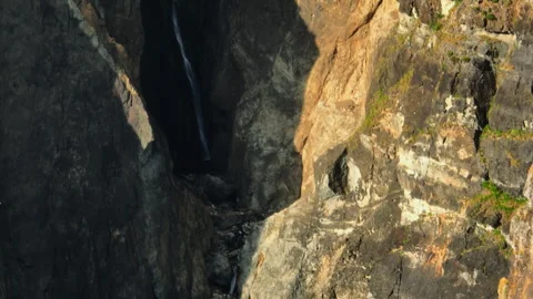 A Thin, Elegant Waterfall Cascades Down a Deep and Moody Volcanic Fissure 库存影片 336262715