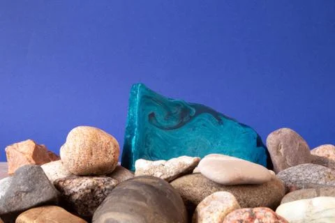 Thin flat piece of blue mint handmade soap lying on a pile of pebble Stock Photos