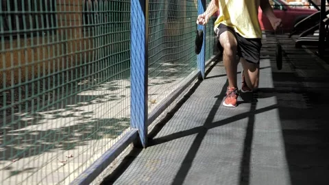 A thin guy is engaged in a street gym. Squats in move with barbells. A man Stock Footage 205212307