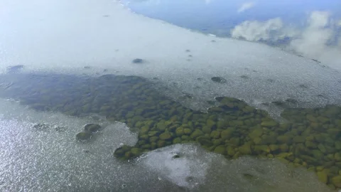 Thin ice on the pond and reflection of the blue sky Stock Footage 321213346