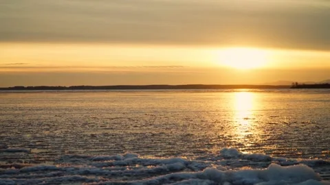 Thin ice on the water surface of the lake in the rays of the setting sun. Stock Footage 286129988