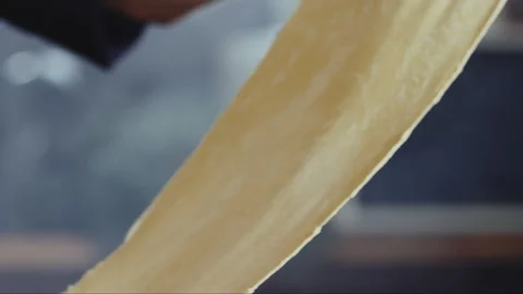 Thin layer of dough coming out of the flattening machine Stock Footage 274608286