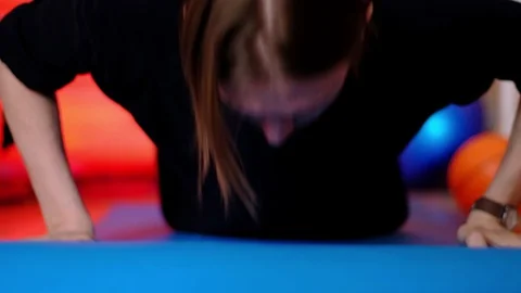 A thin long-haired man in dark clothes is pushing himself from the floor of the Stock-Footage 128649901