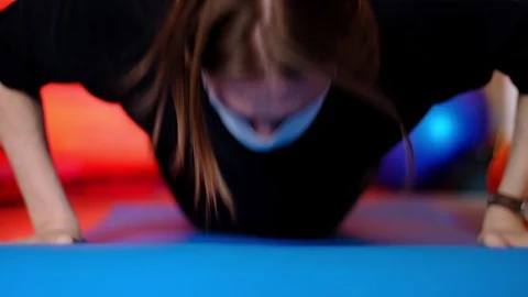 A thin long-haired man in dark clothes and a medical mask is pushing himself fro 動画素材 128650042