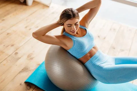 Thin lovely lady doing physical exercises for her abs Stock Photos