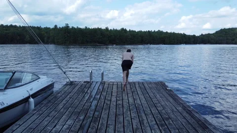 Thin man takes running dive into lake Stock Footage 231001597