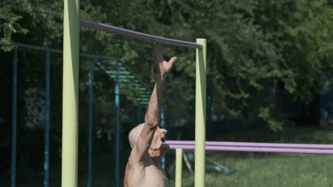 Thin old man tries to reach crossbar to do acrobatic tricks Stock Footage 201959303