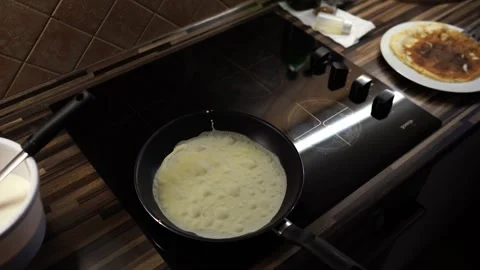 Thin pancake is baked in a frying pan with bubbles Stock Footage 268211569