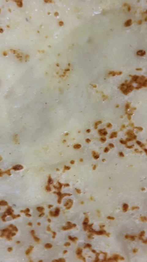 Thin pancake or crepe cooking on a hot surface Video stock 331973707