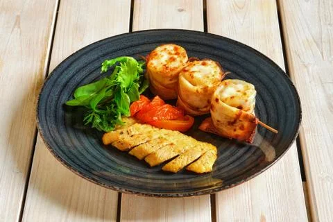 Thin pancakes stuffed with soft cheese rolled and put on skewer Foto stock