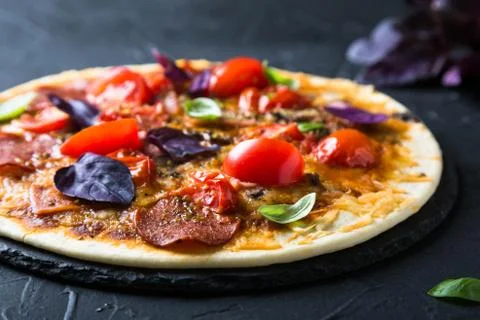 Thin pizza with pepperoni and fresh basil Stock Photos