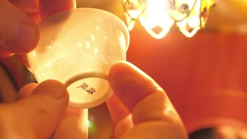 A thin porcelain cup is translucent. Tea ceremony. Handwork Stockbeeldmateriaal 147279022