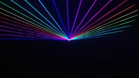 Thin rainbow laser beams shine over top half of black background Stock Photos