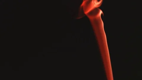 A thin red jet of smoke moves up against a black background. Magical fog in slow Stock Footage 125640782