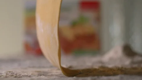 The thin rolled dough falls on the table with flour. Video stock 83723663