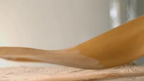 The thin rolled dough falls on the table with flour. Stock Footage 83723771