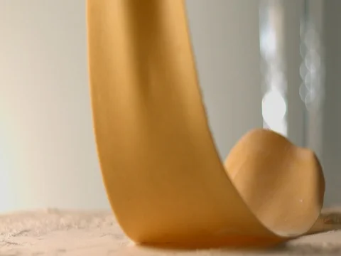 The thin rolled dough falls on the table with flour. Stock Footage 83723817