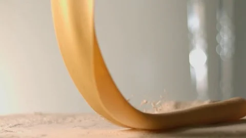 The thin rolled dough falls on the table with flour. Stock Footage 83723907