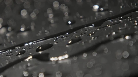 Thin runlet of rainy water creeping among splashing spots in slow motion Video stock 101762293