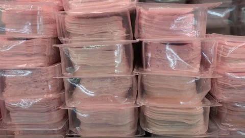 Thin sliced deli meat packed in plastic trays in refrigerated grocery display Stock Footage 345979139