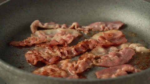 Thin slices of bacon sizzling in teflon frying pan, harmful cooking with Stock Footage 150587288
