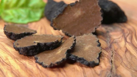 Thin slices of black truffle lying on a wooden board Stock Footage 73459226
