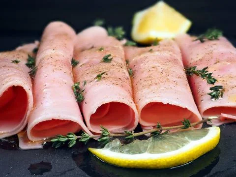 Thin slices of cooked ham served with olive oil, thyme, rosemary, spices and 写真素材