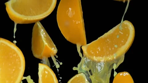 Thin slices of orange are bouncing with the splashes of the orange juice Stock Footage 185066787
