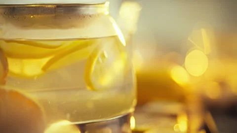 Thin slices of raw citrus fruit probably lemon and ginger are infused in a t Stock Footage 331363696