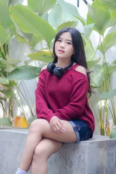 Thin smiling girl relaxing while sitting around in oudoor cafe Stock Photos
