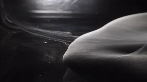 Thin smoke spreads across the dark surface, creating a mystical veil. Ethereal Stock Footage 306460876
