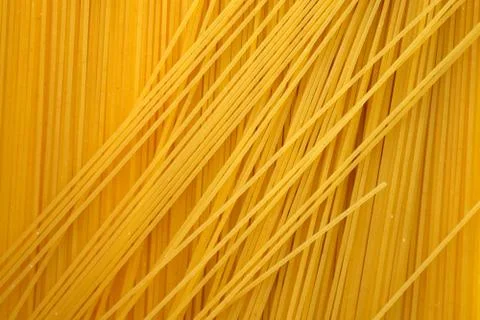 Thin spaghetti background top view. Uncooked raw spaghetti. Stock Photos